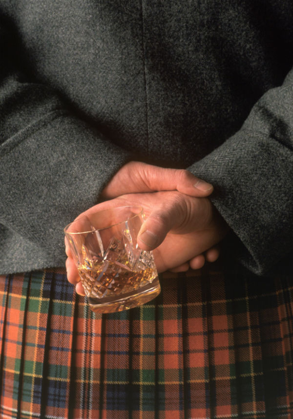 Scottish kilt man holding a whisky dram